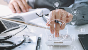 An accountant working on a project inputting numbers in a calculator.
